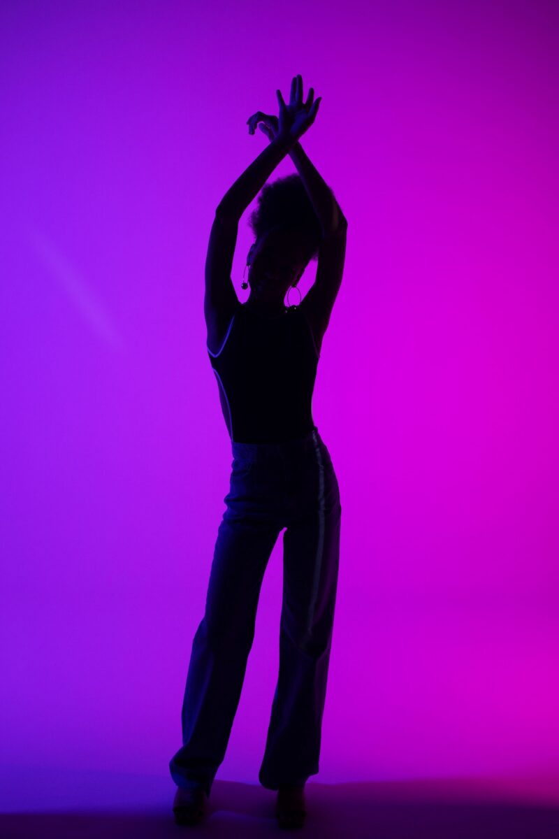 Artistic silhouette of a woman posing intricately with a vibrant purple background.
